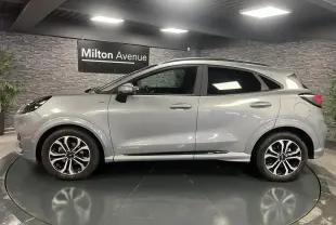 Ford Puma gris Solar en vue profil côté gauche, avec barres de toit noires et jantes alliage 17 pouces.