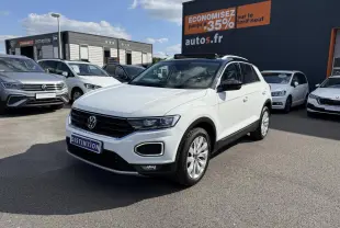 Volkswagen T-Roc blanc en 3/4 avant droit, avec toit ouvrant et jantes alliage visibles, sur parking extérieur.