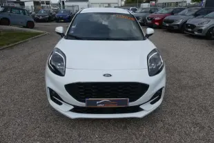 Vue avant d'une Ford Puma blanche ST Line avec calandre noire et phares LED, sur un parking extérieur.