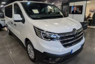 Renault Trafic Combi blanc glacier vu en 3/4 avant droit, mettant en valeur sa calandre chromée et ses phares LED.