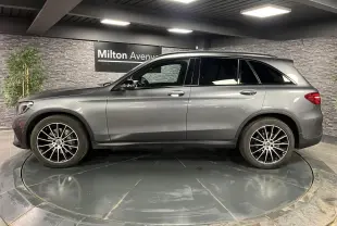 Profil droit d'un Mercedes GLC gris métallisé 2019 avec jantes alliage AMG 20 pouces multibranches dans un showroom.