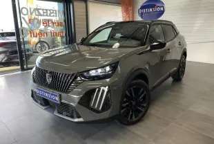 Peugeot 2008 gris en 3/4 avant droit, avec calandre noire distinctive et jantes alliage noires, en showroom.