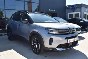 Citroën C5 Aircross 2024 gris métallisé en 3/4 avant droit avec toit bi-ton noir Perla Nera visible.