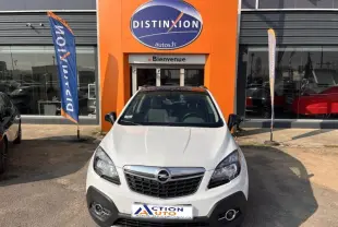 Opel Mokka blanc glacier vue de face, calandre chromée et phares halogènes visibles devant un garage Distinxion.
