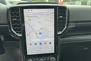 Vue rapprochée de l’écran tactile central du Ford Ranger 2025 noir agate, affichant la navigation GPS et commandes climatisation.