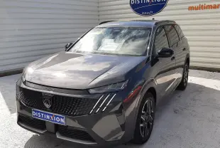 Peugeot 5008 Hybrid gris titane métal en 3/4 avant droit, avec calandre noire et phares LED distinctifs.
