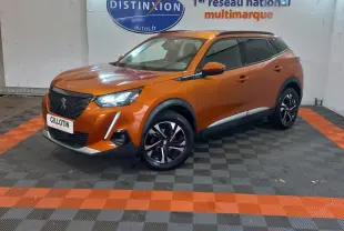 Peugeot 2008 orange en 3/4 avant droit, avec phares LED allumés et jantes noires à motifs argentés.