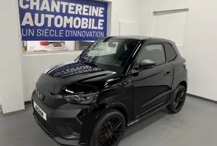 Vue 3/4 avant d'une Ligier JS50 noire mate avec jantes alu noires et badge Ultimate visible sur l'aile avant droite.