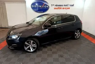Peugeot 308 GT Line gris foncé vue de profil côté gauche dans un showroom avec éclairage intérieur.