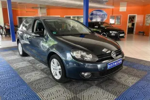 Volkswagen Golf VI gris vue 3/4 avant droit dans un showroom avec logo Distinxion en arrière-plan.