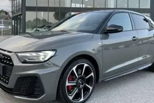 Audi A1 Sportback 30 TFSI S-Line 2025 en gris Chronos avec toit noir, vue 3/4 avant côté gauche et jantes alu 18 pouces.