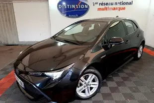 Toyota Corolla hybride noire vue en 3/4 avant droit dans un showroom avec jantes argentées et logo Distinxion en arrière-plan
