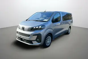 Peugeot Traveller gris acier en 3/4 avant droit, avec vitres surteintées et jantes alliage visibles.