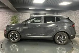 Vue latérale droite du KIA SPORTAGE gris métallisé 2022 avec jantes alliage 17 pouces et poignées chromées.