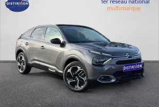 Citroën C4 gris 2024 vue 3/4 avant droit, avec jantes noires et détails lumineux distinctifs à l'avant.