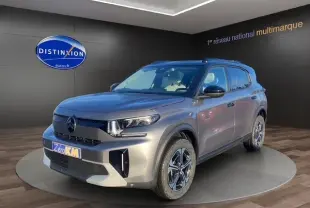 Vue 3/4 avant d'un Citroën C3 Aircross gris foncé avec jantes distinctives et toit noir en showroom.