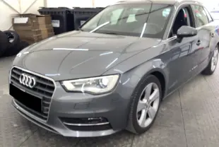 Audi A3 Sportback gris vue 3/4 avant droit, avec calandre distinctive et jantes alliage cinq branches.