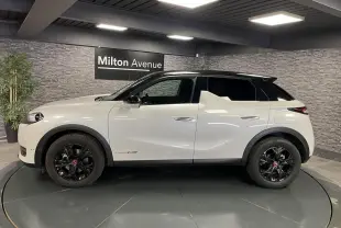 Vue latérale gauche d'un DS3 Crossback 2022 bi-ton blanc et noir avec jantes noires et badges Performance Line visibles.