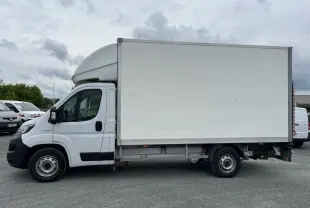 Fourgon FIAT Ducato Maxi Business blanc vu de profil côté gauche avec grande caisse de chargement fermée.