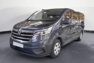Renault Trafic Combi gris comète en 3/4 avant droit, mettant en valeur sa calandre chromée et ses grandes vitres latérales.