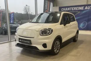 Vue 3/4 avant d'une Leapmotor T03 Luxury blanche avec toit noir, phares LED et jantes alliage en showroom.