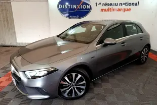 Vue 3/4 avant droite d'une Mercedes Classe A A 250 e Business Line grise avec jantes alliage et phares LED allumés.