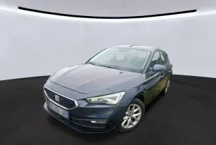 SEAT Leon gris vue 3/4 avant droit, mettant en valeur les phares LED et la calandre hexagonale distinctive.