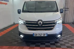 Vue frontale d’un Renault Trafic Fourgon blanc 2022 avec phares LED allumés dans un garage.