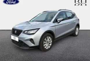 SEAT Arona gris Urbain Métal en vue 3/4 avant droit, avec calandre noire et jantes alu simples.