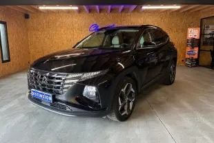Hyundai Tucson noir 2022 en 3/4 avant droit, avec calandre distinctive et jantes modernes, dans un showroom intérieur.