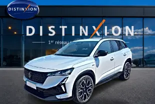 Renault Austral blanc nacré en 3/4 avant droit, avec jantes alu noires et toit noir contrasté devant showroom Distinxion.