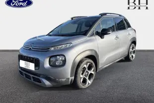 Citroën C3 Aircross gris acier vue 3/4 avant droit avec barres de toit et jantes diamantées noires et argentées.