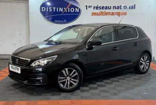Peugeot 308 Puretech noir vue de 3/4 avant droit, avec phares allumés et jantes alliage distinctives.