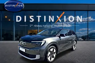 Ford Explorer électrique gris en vue 3/4 avant droit devant une vitrine avec logo Distinxion.