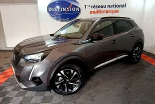 Peugeot 2008 gris foncé en 3/4 avant droit, avec jantes noires et toit noir dans un showroom intérieur.