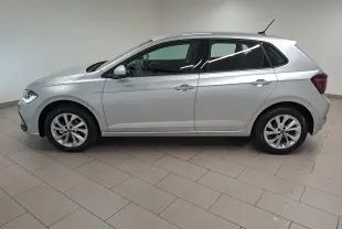 Profil droit d'une Volkswagen Polo 1.0 TSI 95 BVM5 Style 2025 en peinture reflet d'argent, avec feux avant allumés.