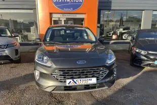 Vue frontale d’un Ford Kuga 2.0 EcoBlue 150ch mHEV Titanium gris Magnetic métallisé, stationné devant un concessionnaire.