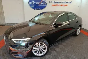Audi A3 30 TFSI MHEV noir vue 3/4 avant droit, avec jantes argentées et phares LED allumés en intérieur showroom.