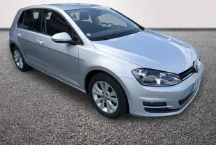 Volkswagen Golf gris clair vue 3/4 avant droit, avec phares halogènes et rétroviseurs électriques rabattables.