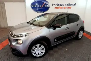 Citroën C3 gris clair vue 3/4 avant droit, avec protections latérales noires et jantes acier à enjoliveurs.