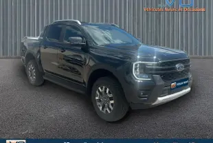 Ford Ranger Wildtrak noir en 3/4 avant droit avec barres de toit, marchepieds et jantes alliage 18 pouces.