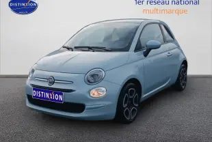 Fiat 500 bleu ciel vue 3/4 avant droit avec phares allumés sur fond neutre.