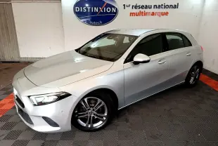 Vue 3/4 avant droit d'une Mercedes Classe A A 180 d Business Line gris clair dans un showroom intérieur.