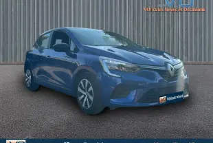 Renault Clio V TCe 90 Equilibre bleu foncé vue 3/4 avant droit sur sol bitumé devant un mur métallique.