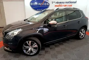 Peugeot 2008 gris foncé vue de profil côté gauche avec jantes alliage et barres de toit chromées.