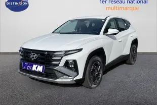 Hyundai Tucson blanc Atlas en 3/4 avant droit, avec calandre noire et jantes bi-ton noires.