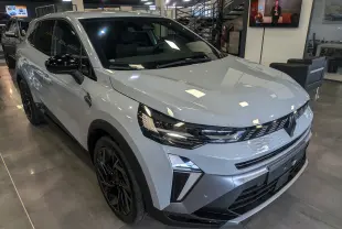 Vue 3/4 avant droite d'une Renault SYMBIOZ E-TECH Full Hybrid gris Rafale avec jantes noires en showroom.