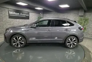 Volkswagen Taigo gris foncé vue de profil côté gauche, avec jantes alliage noires et toit noir.