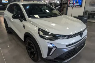 Renault SYMBIOZ blanc nacré en 3/4 avant droit, avec jantes noires et détails noirs contrastants sur les rétroviseurs.