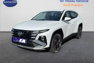 Hyundai Tucson blanc Atlas vu en 3/4 avant droit, avec calandre noire et jantes alliage foncé.